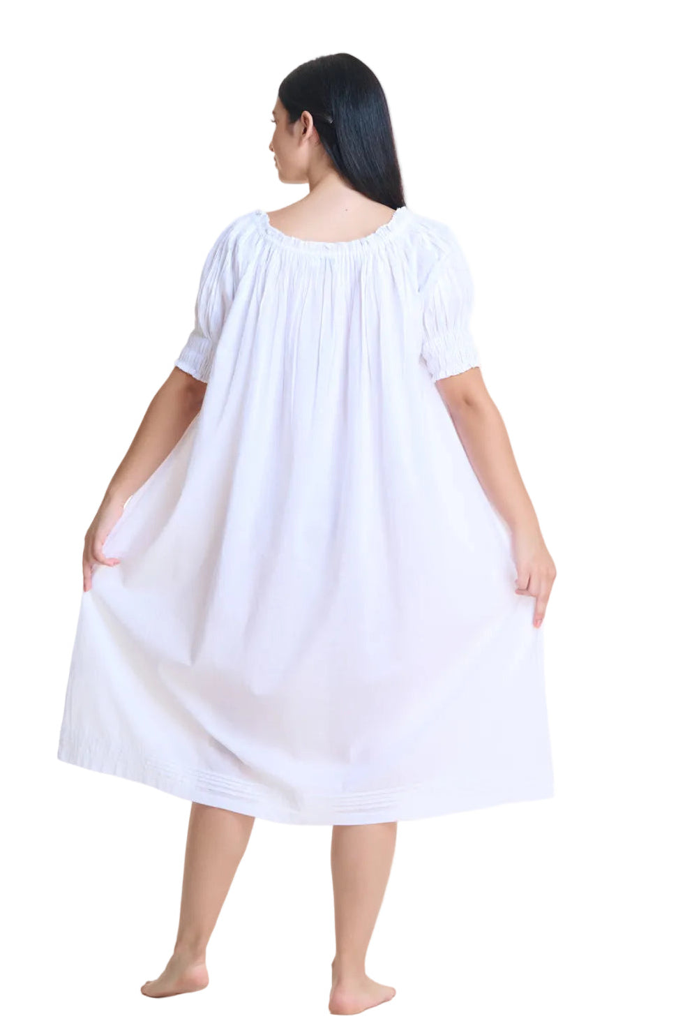 Short sleeved pin tucked white nightdress with puffed sleeves and front ribbon. This retro style cotton nightdress features delicate pleating, an empire waistline accentuating the bust and flowing out from there. Made of 100% cotton.