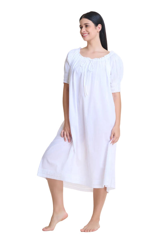 Short sleeved pin tucked white nightdress with puffed sleeves and front ribbon. This retro style cotton nightdress features delicate pleating, an empire waistline accentuating the bust and flowing out from there. Made of 100% cotton.