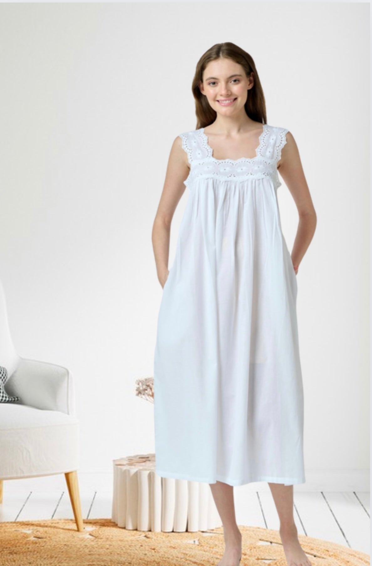beautiful white cotton nightdress with classic romantic details. The most striking feature is the scalloped eyelet lace trim around the square-cut back neckline. The dress has a loose, flowy empire-waist silhouette that falls from just below the bust line. The bodice features delicate eyelet embroidery work. The shoulder straps are also decorated with the same eyelet lace trim. The overall style is reminiscent of vintage or Victorian inspired sleepwear