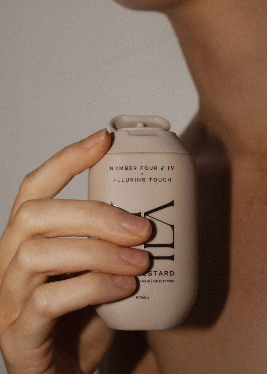 Hand holding a beige bottle labeled 'Number Four' against a neutral background