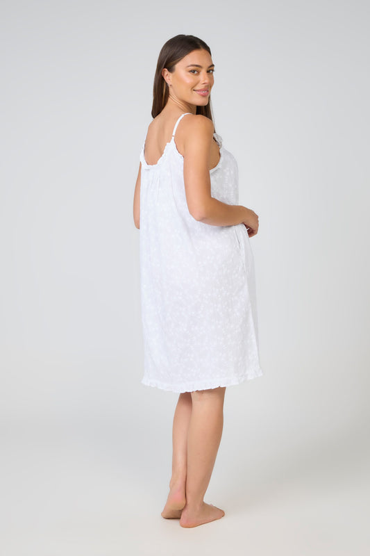 Woman wearing a white slip dress on a plain background