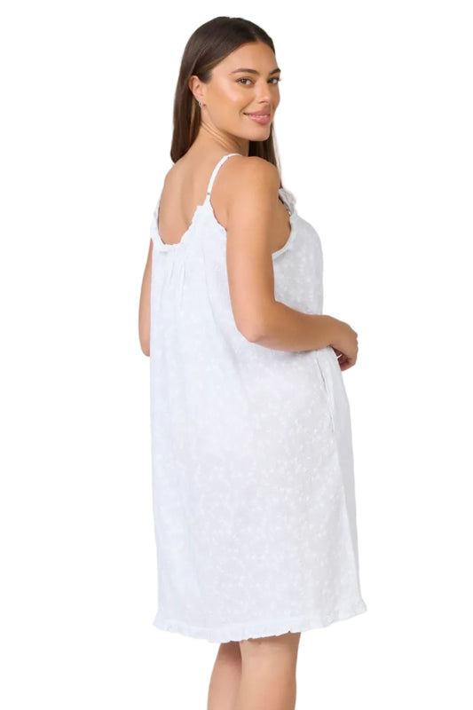 Woman wearing a white slip dress on a plain background
