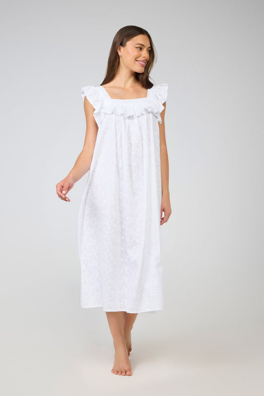 Woman wearing a white nightgown against a plain background