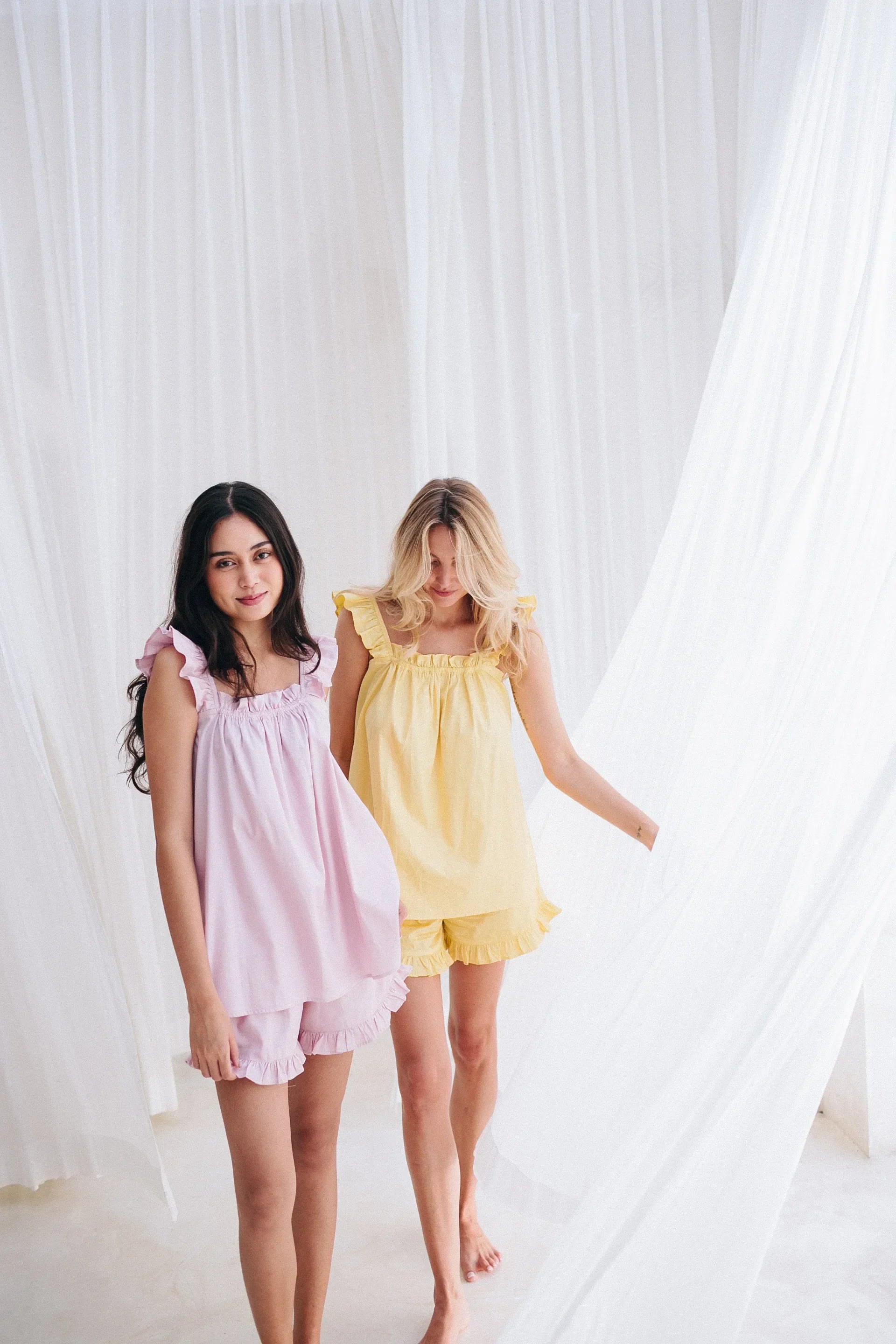 Girls wearing PJ short frill sets in pink and yellow