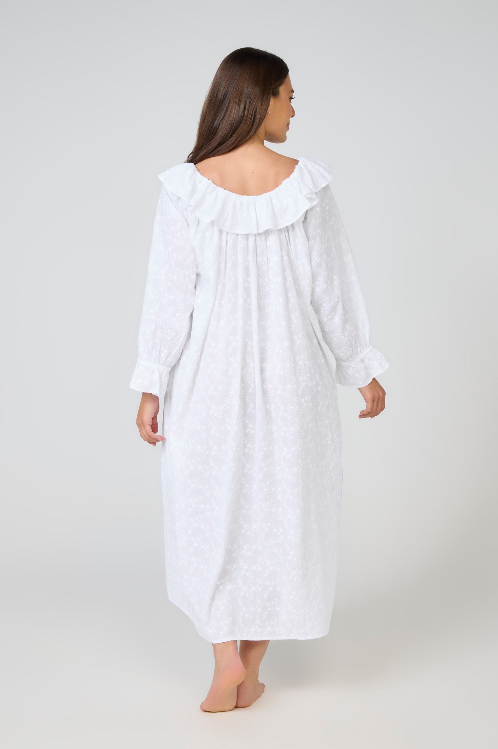 Woman wearing a white nightgown with a ruffled collar on a white background