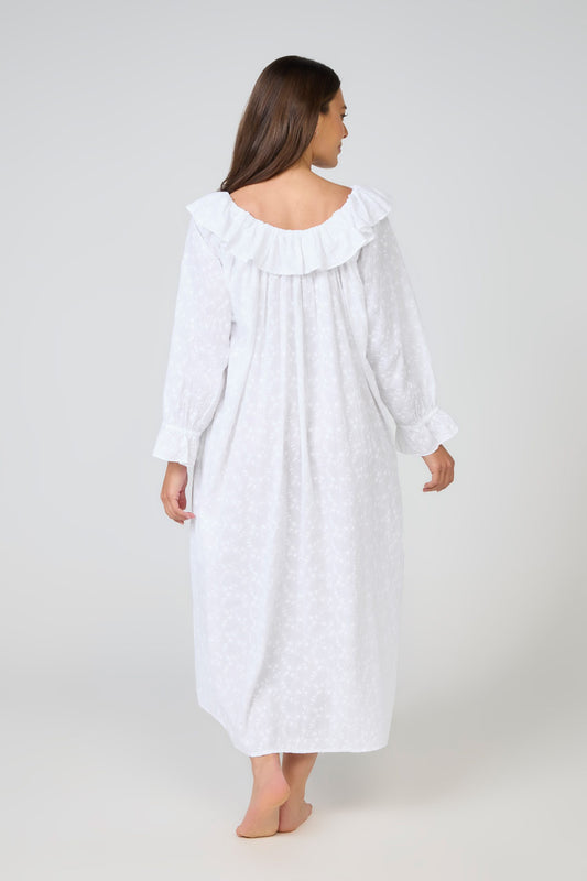 Woman wearing a white nightgown with a ruffled collar on a white background